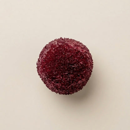 Dark Red berry slushy squishy stress ball. Color is burgundy cherry.  Squishy ball best for asmr fidgets toy. A single dark red, textured spherical squishy ball with a rough, crystalline or granular surface, centered on a plain off-white background.