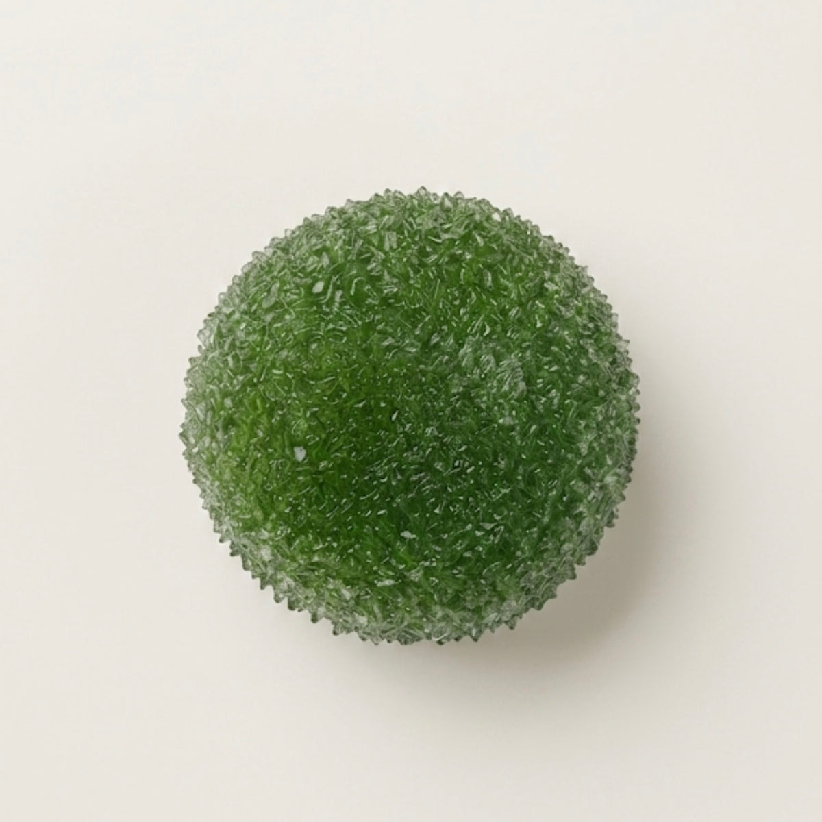 Matcha berry slushy squishy stress ball. Color is Matcha green.  Squishy ball best for asmr fidgets toy. A green, textured spherical decorative object with a granular, bubbly surface, photographed from directly above on a plain off-white background.
