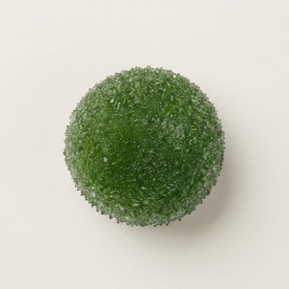 Matcha berry slushy squishy stress ball. Color is Matcha green.  Squishy ball best for asmr fidgets toy. A green, textured spherical decorative object with a granular, bubbly surface, photographed from directly above on a plain off-white background.