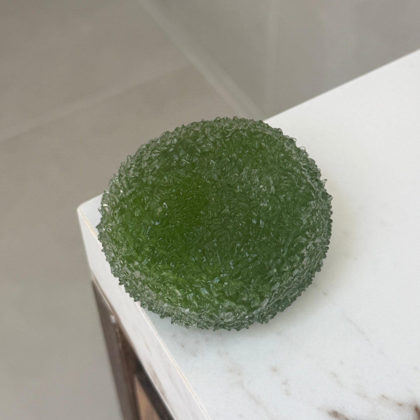 Matcha Green shaved ice texture ASMR squishy ball with a soft, flexible crystal-like surface displayed on a marble countertop.