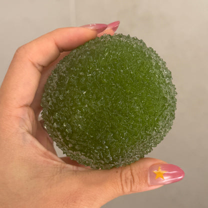 Soft green shaved ice texture ASMR squishy ball held in hand, showing its flexible crystal-like surface and palm-sized design.