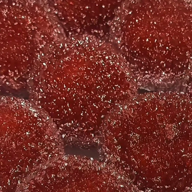 Close-up of glossy red shaved ice ASMR squishy balls with a soft crystal-textured surface.