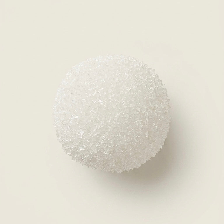 Snow berry slushy squishy stress ball. Color is Snow White.  Squishy ball best for asmr fidgets toy.A white, textured spherical sponge or foam ball photographed from above on a plain warm off-white background.