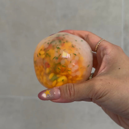 Handheld egg and green onion fried rice squishy stress ball with gel filling, artificial rice grains, and realistic food-inspired details.