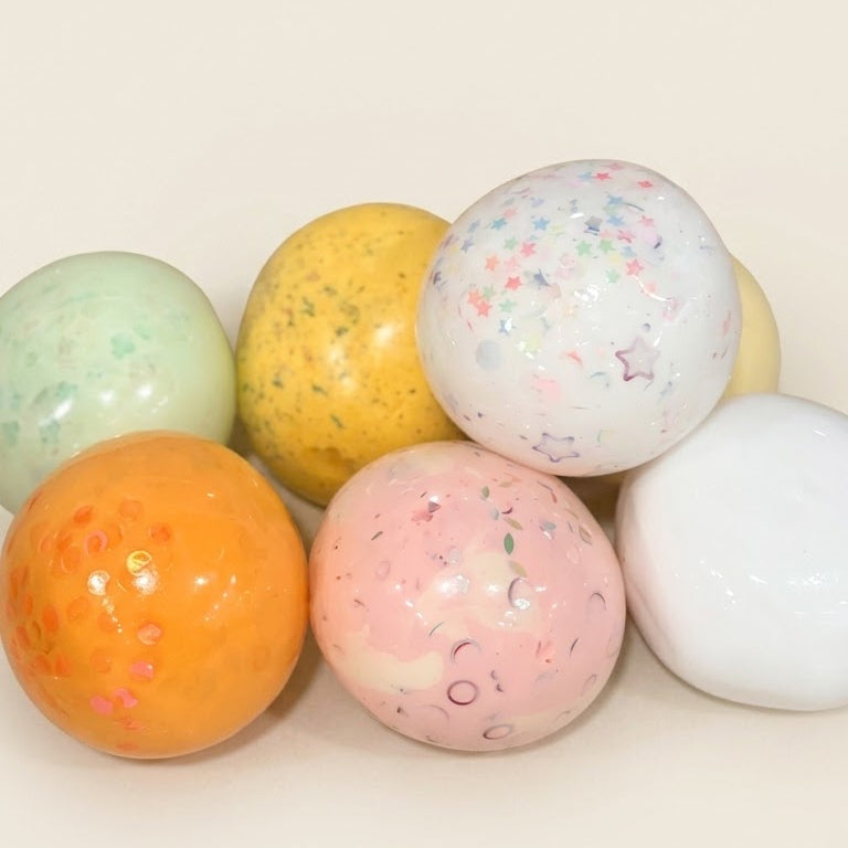 Featured handmade squishy stress balls from the SQUU Artistic Handmade Collection with assorted colors, textures, and decorative details.