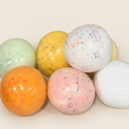 Featured handmade squishy stress balls from the SQUU Artistic Handmade Collection with assorted colors, textures, and decorative details.