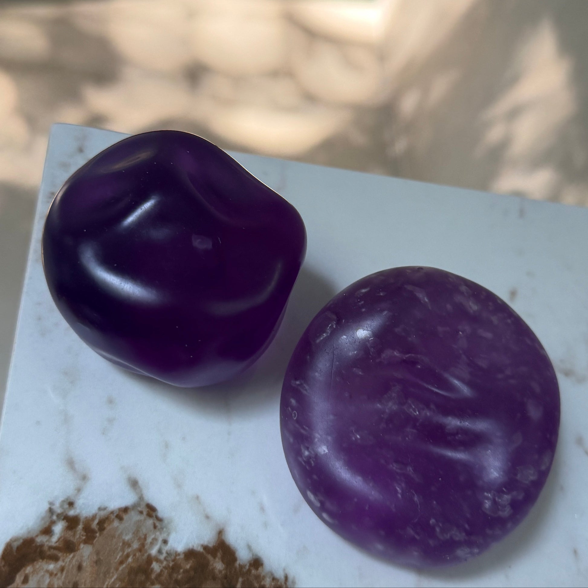 Crystal purple grape squishy stress balls showing before-and-after bubble texture from repeated squeezing, with ultra-soft zero-rebound filling.