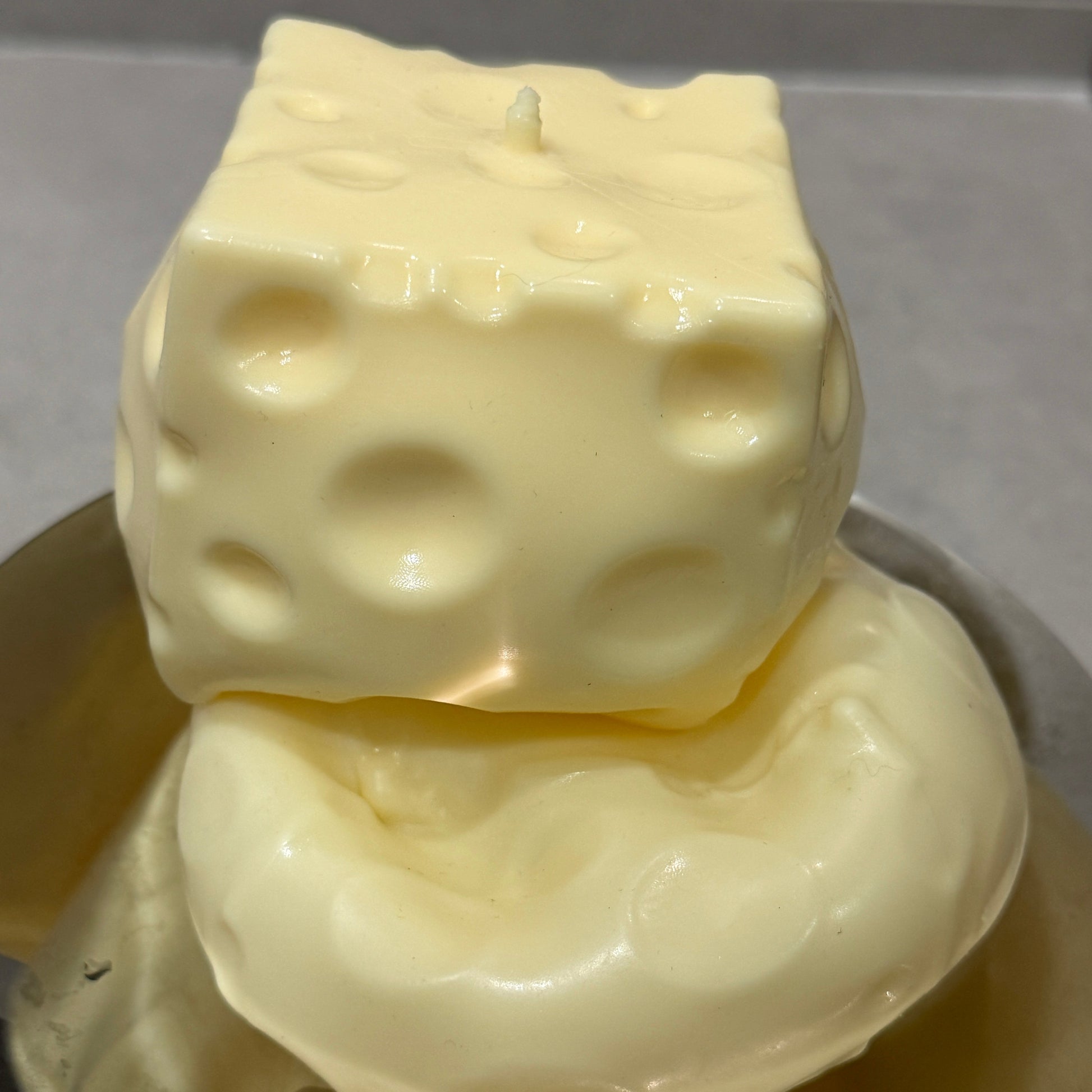 Jumbo cheese squishy stress ball sensory toy showing its soft moldable texture and compressed shape after squeezing.