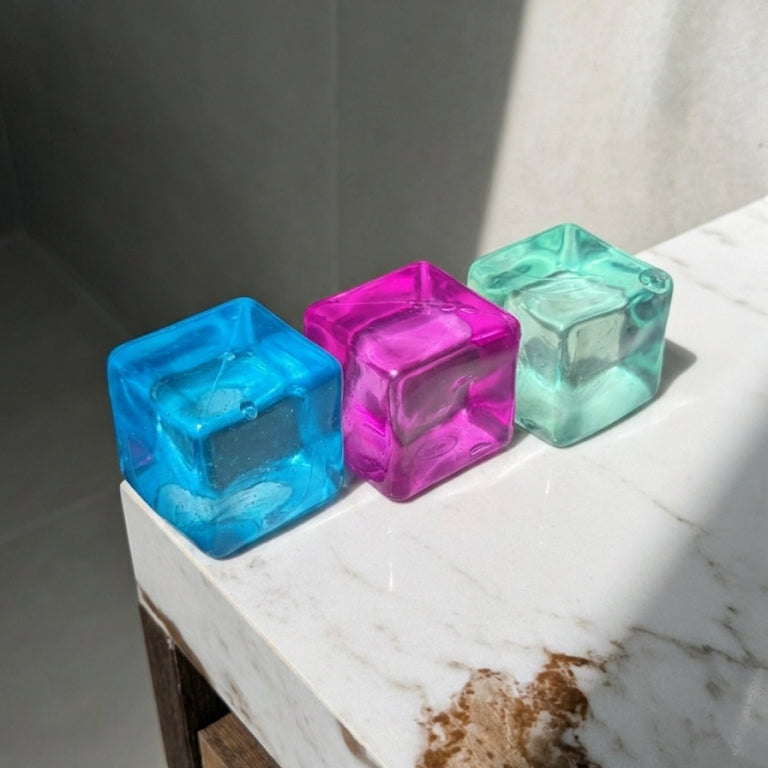 Translucent maltose cube squishy stress toys in blue, pink, and mint with soft moldable texture and satisfying slow rebound.