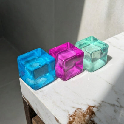 Translucent maltose cube squishy stress toys in blue, pink, and mint with soft moldable texture and satisfying slow rebound.