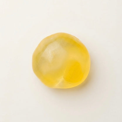 Orange coconut oil sugar ball squishy stress ball with a translucent glossy finish and soft moldable texture.