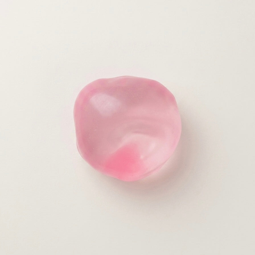 Pink coconut oil sugar ball squishy stress ball with a translucent glossy finish and soft moldable texture.