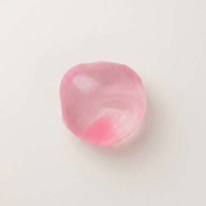 Pink coconut oil sugar ball squishy stress ball with a translucent glossy finish and soft moldable texture.