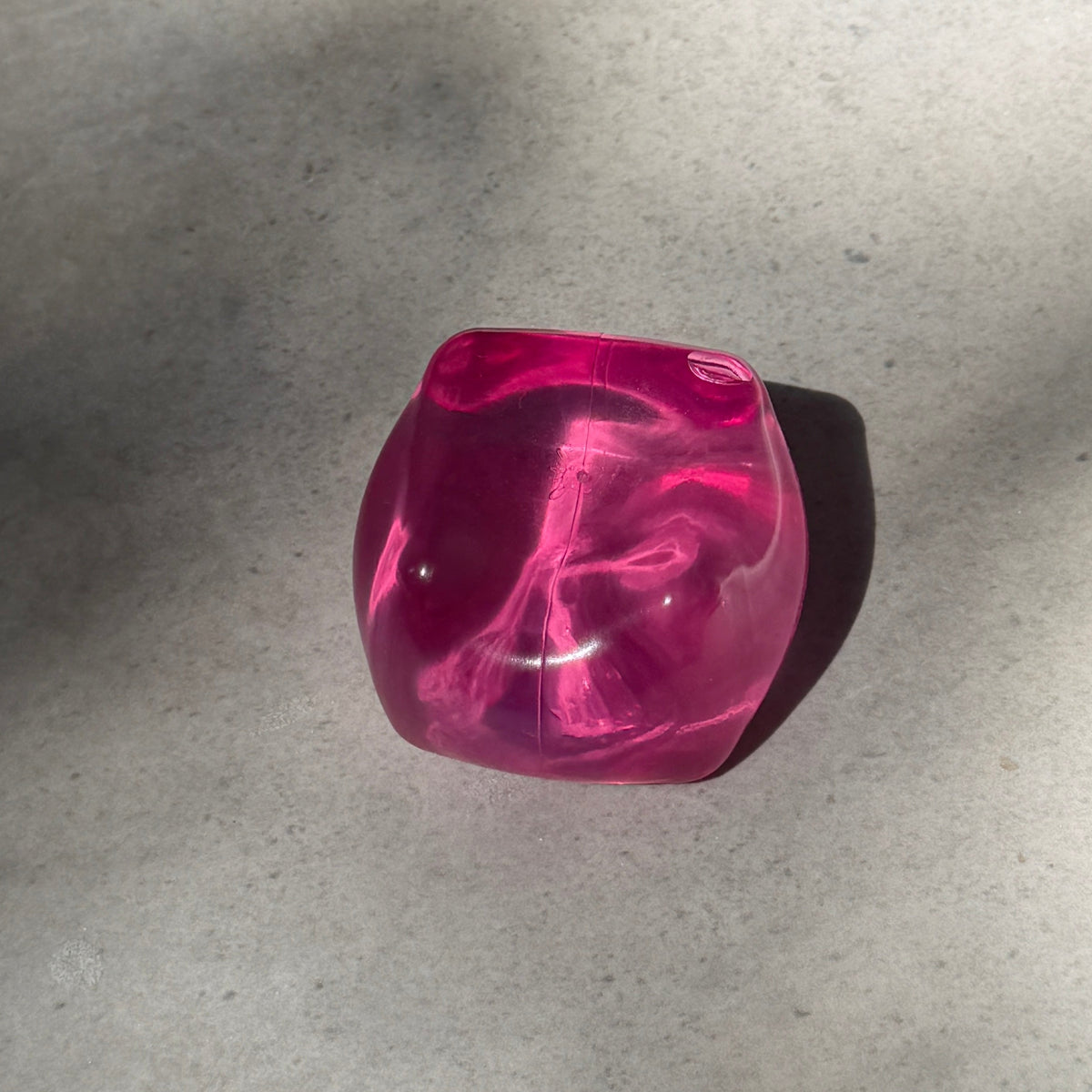 Pink maltose cube squishy stress toy with translucent glossy finish, soft moldable texture, and satisfying slow rebound after squeezing.