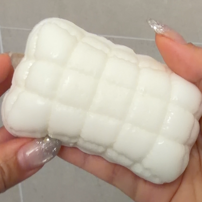 Handheld ultra-soft sticky Mellow Pillow TABA squishy sensory toy with a white quilted cushion shape for bare-hand or bag play.