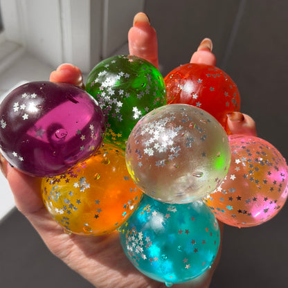 Assorted vintage-style maltose squishies in translucent colors with star-shaped glitter confetti and soft slow-rebound texture.